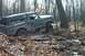 1979 Ford Bronco - Ford Bronco tackles a challenging muddy off-road course in a wooded area.