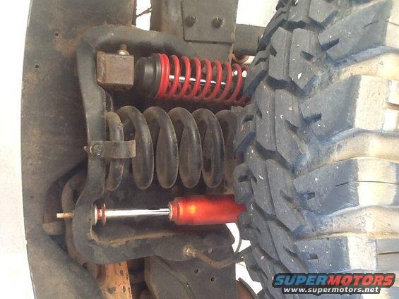Off-road tire and suspension with red coilover shock and black springs
