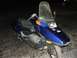 2006 Honda Reflex - A blue scooter is parked on a cracked asphalt surface at night.