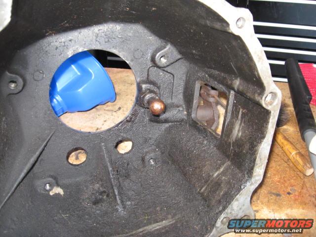 Transmission bell housing with blue funnel inside, on a workbench