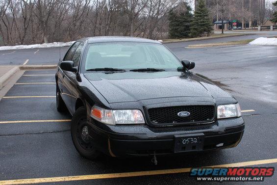 Black Ford Crown Victoria parked in a lot. License plate reads 0532