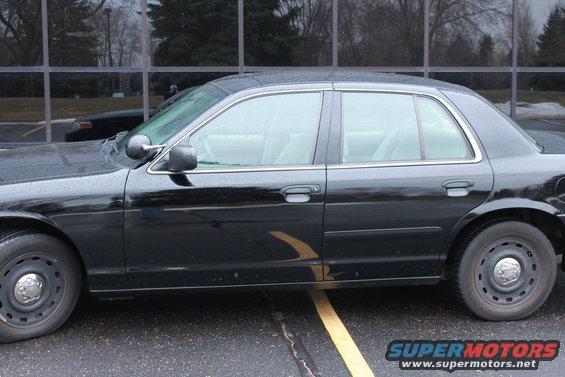 Side view of a black 2005 Ford Crown Victoria sedan with steel wheels
