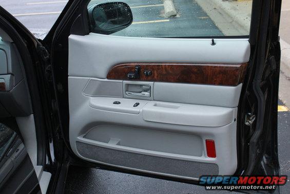 Interior door panel with wood trim and gray upholstery