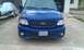 2003 Ford F-150 - Front view of a blue 2003 Ford F-150 Lightning, parked in front of a garage.