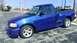 2003 Ford F-150 - This blue 2003 Ford F-150 pickup truck is shown from a 3q-front angle.