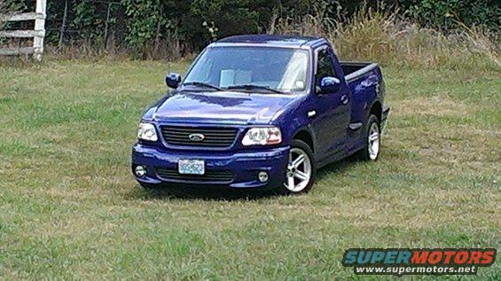 Blue 2003 Ford F-150 Lightning pickup truck parked on grass