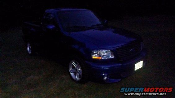 Blue 2003 Ford F-150 parked on grass at night