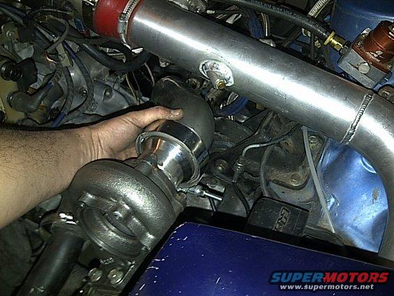 Hand installing turbocharger in engine bay