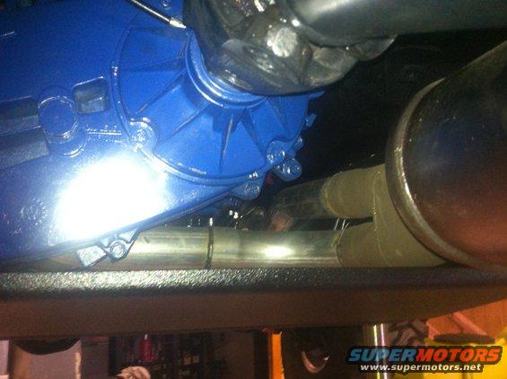 Blue painted transmission and exhaust pipes under a vehicle