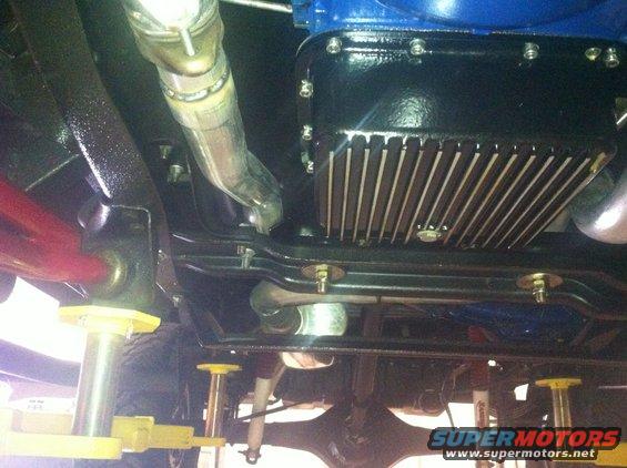 Underside view of a vehicle showing the engine oil pan and exhaust pipe