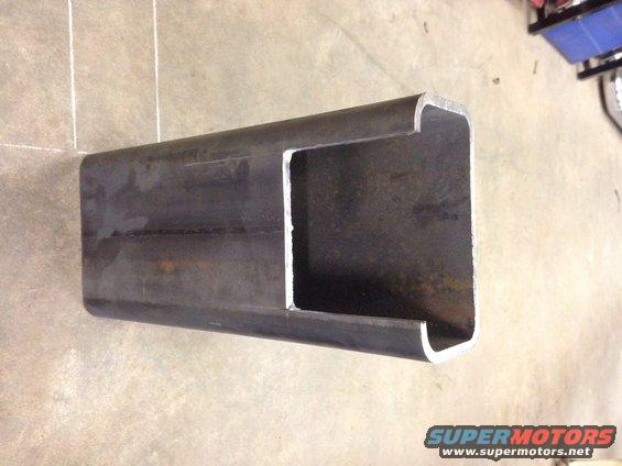 Metal C-channel part on concrete floor. Supermotors.net logo visible