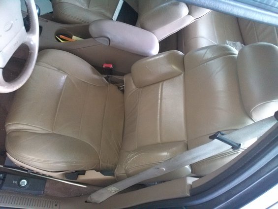 Tan leather interior of a 1993 Ford Taurus, showing front seats, steering wheel, and center console