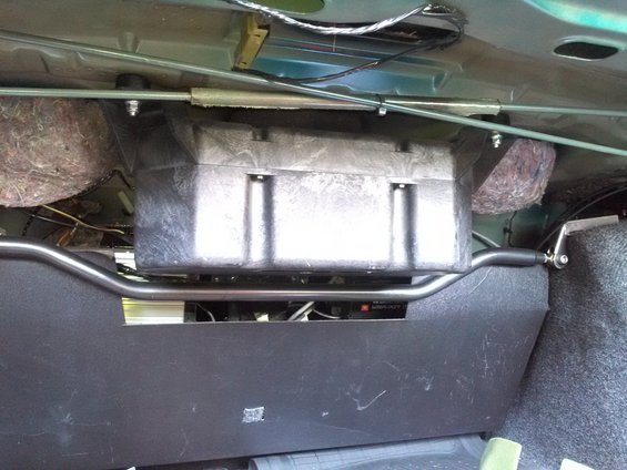 Car trunk interior with a subwoofer box, amplifier, and sound deadening material
