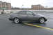 2002 Lexus IS 300 - A dark gray 2002 Lexus IS 300 sedan is parked on a rooftop parking lot with buildings in the background.
