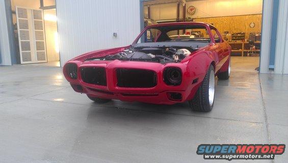 Red 1970s muscle car front view, hood open