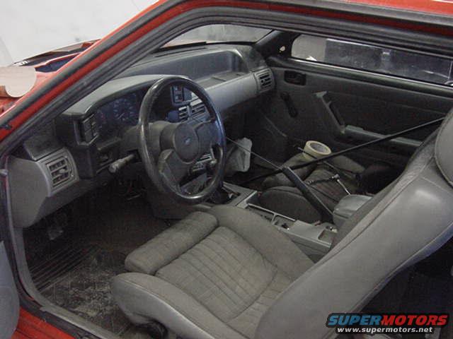 Interior view of a red car, showing dashboard, steering wheel, seats, and center console