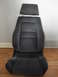 1972 Ford Pinto - This is a dark gray Recaro car seat with a red logo visible on the backrest.