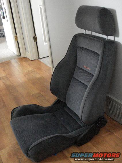 Gray Recaro car seat with orange logo, seen from the side