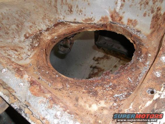 rusted metal frame with a large hole in the center, showing some internal structure