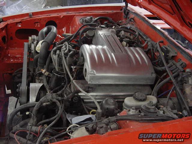engine bay with V8 engine, hoses, and wiring