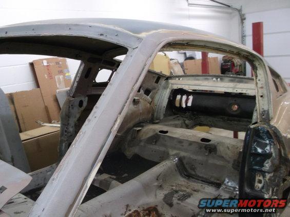 car body stripped down, showing interior structure and rust damage