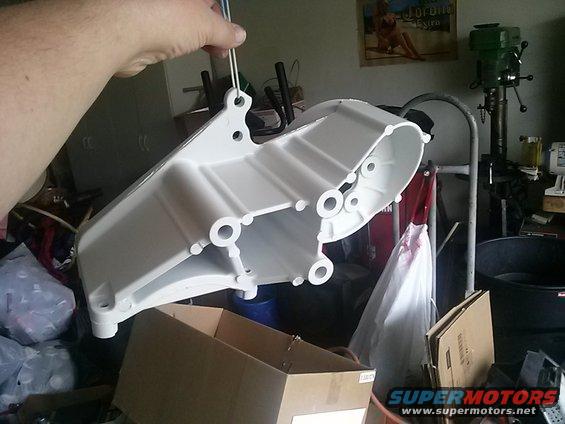 White painted metal part hanging from wires