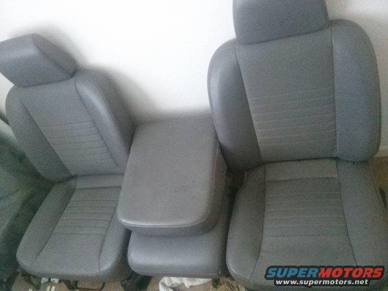 Gray fabric car seats and center console against a white wall
