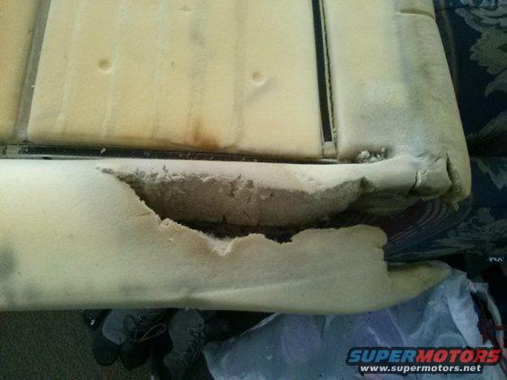 Damaged car seat foam with a large tear exposing the interior padding