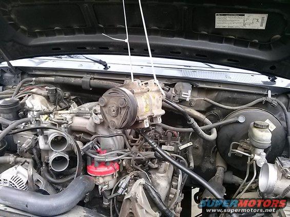 Engine bay of a 1996 Ford Bronco with AC compressor removed