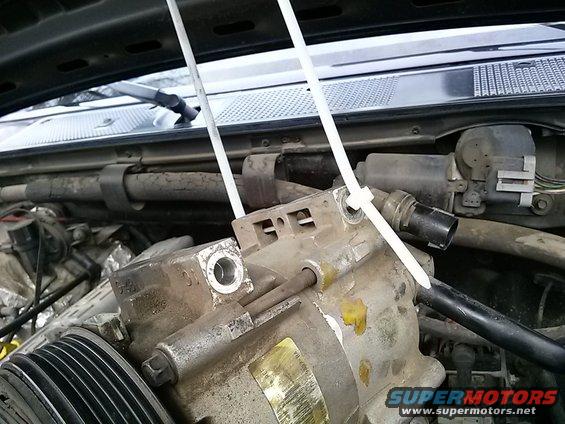 Engine component secured with zip ties, showing part numbers
