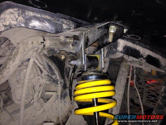 Close-up of yellow ATV shock absorber and mounting bracket