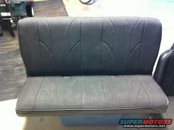 Gray car seat with vertical stitching and curved accents on the backrest