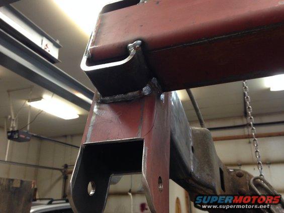 Close-up of welded red metal frame section with bolts