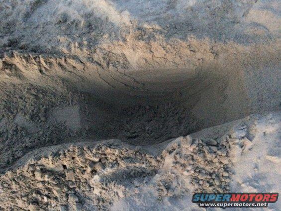 Tire tracks impressed into sand, showing the pattern of a tire tread