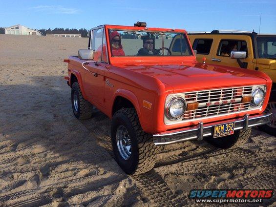 Orange convertible SUV on sand, front view. License plate MEM 352