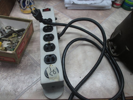 Power strip with multiple outlets and a box of assorted keys