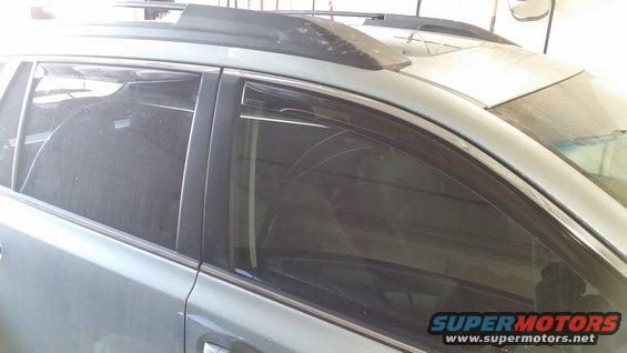 Side view of dark window visors on a silver SUV