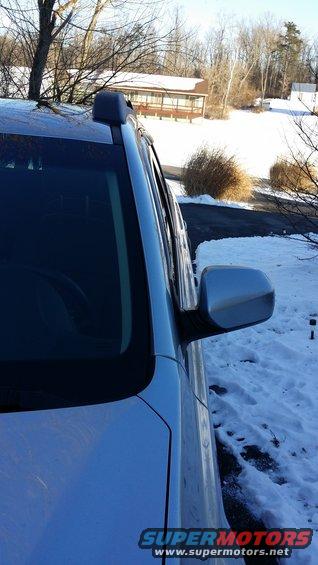 Side view of a car with a roof rack in a snowy area. Watermark says SUPERMOTORS