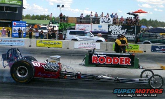 Red dragster with number 85 on side at a drag strip