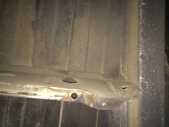 Underside of a truck bed with some rust and holes