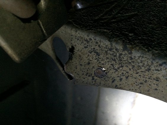 Rusted metal frame with a hole, close-up view