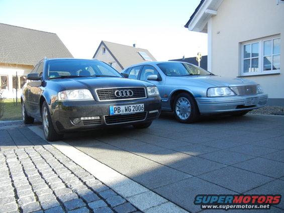 Audi A6 and a light blue sedan parked on paved driveway
