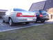 1999 Ford Fairlane - Two cars are parked in a driveway, one silver sedan and one black wagon.