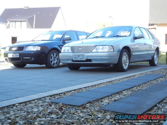 Silver sedan parked on driveway, front quarter view. Grille and headlights visible