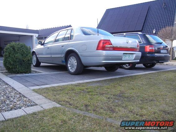 Silver sedan's rear view, license plate 597 DCT, parked next to a dark SUV
