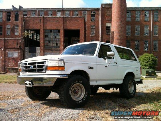 White 1992 Ford Bronco parked in front of an old brick building
