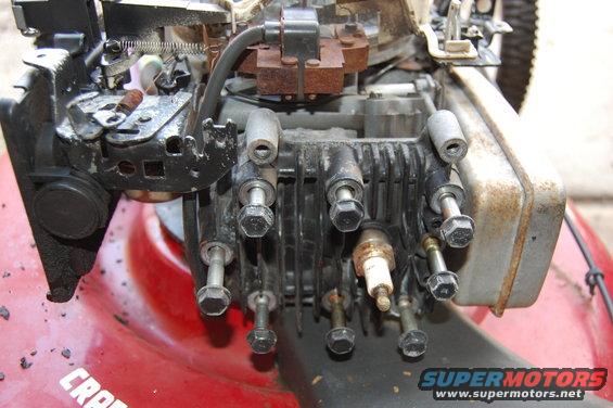 Close-up of a lawn mower engine with spark plug visible