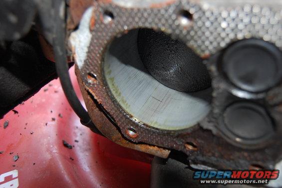 Engine cylinder with scored walls and a damaged gasket, close-up view