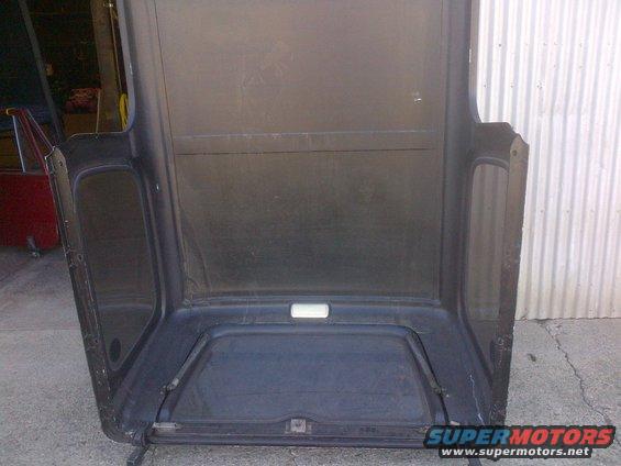 Interior view of a black Jeep CJ hardtop, showing the headliner and window frames