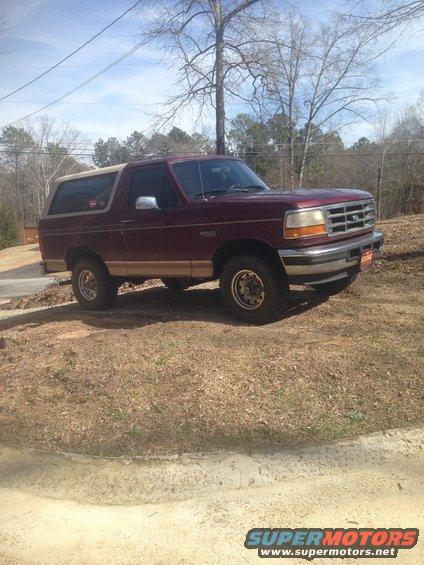 1996 Ford Bronco parked on a dirt lot, side and front view